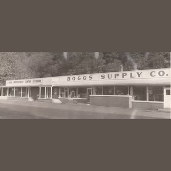 Black and white photo of a vintage storefront, "Boggs Supply Co." The building has large windows and a "Home Improvement Center" sign. Nostalgic tone.