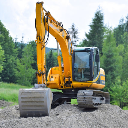 Earth Moving / Lawn & LandscapeA yellow excavator with a large bucket operates on a mound of dirt in a forested area. The sky is partly cloudy, and trees are in the background.