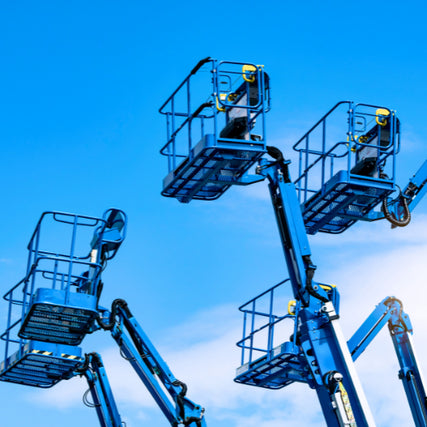 Aerial Work PlatformsFour blue scissor lifts are elevated against a bright blue sky. The image conveys a sense of height and industrial capability.